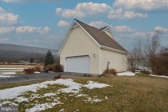 view of snow covered exterior featuring a mountain view and a yard