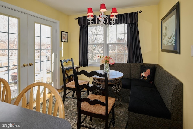 dining space with a notable chandelier, plenty of natural light, and french doors