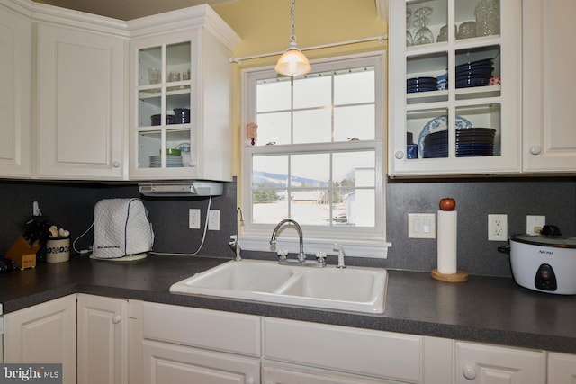 kitchen with white cabinetry, sink, and hanging light fixtures