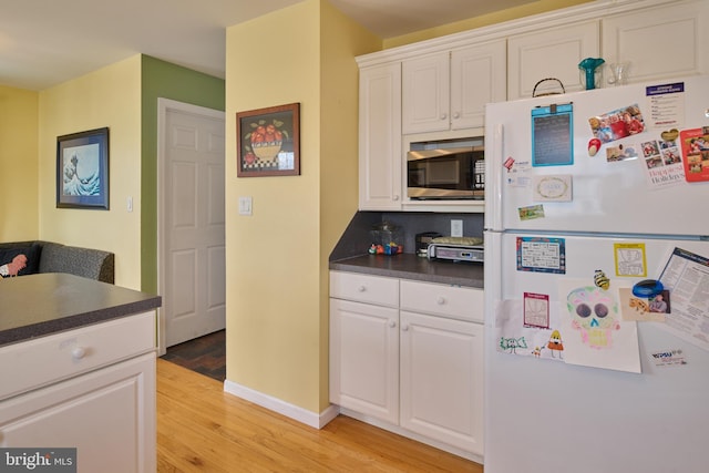 kitchen with white cabinetry, light hardwood / wood-style floors, and white refrigerator