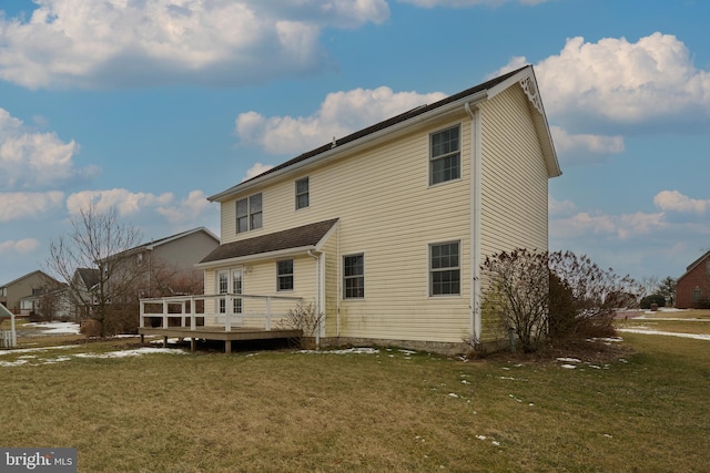 rear view of property featuring a deck and a lawn