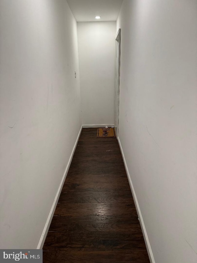 corridor with dark hardwood / wood-style flooring