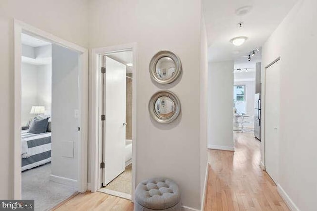 hallway with light hardwood / wood-style floors