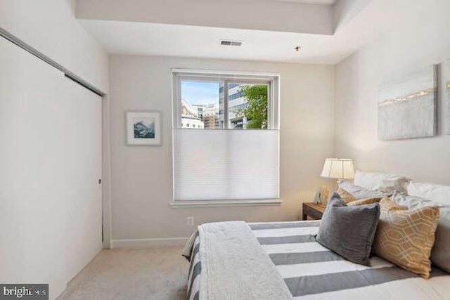 bedroom featuring light carpet and a closet