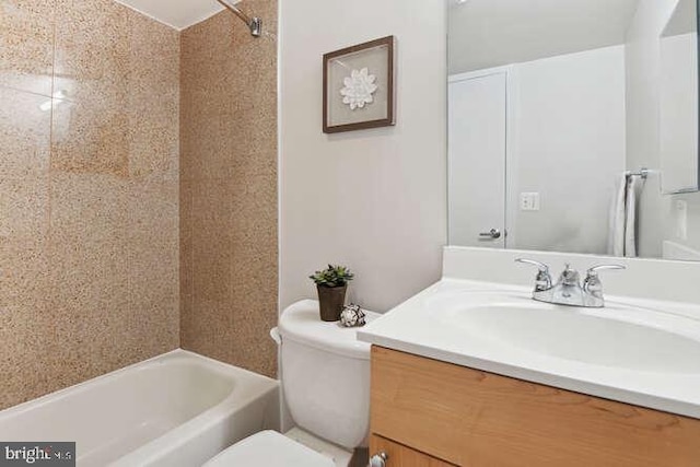 full bathroom featuring vanity, tiled shower / bath, and toilet