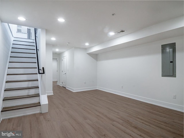 basement with wood-type flooring and electric panel