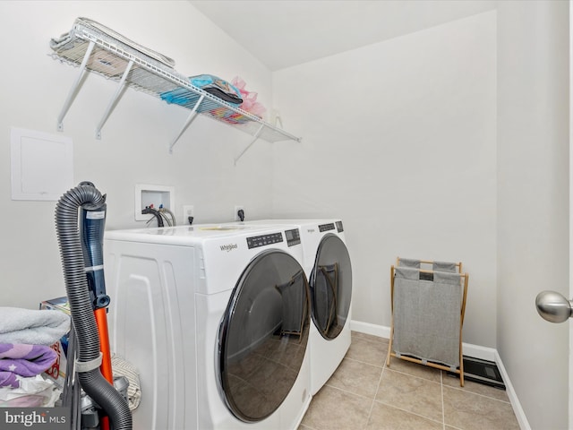 laundry area featuring washer and dryer and light tile patterned floors