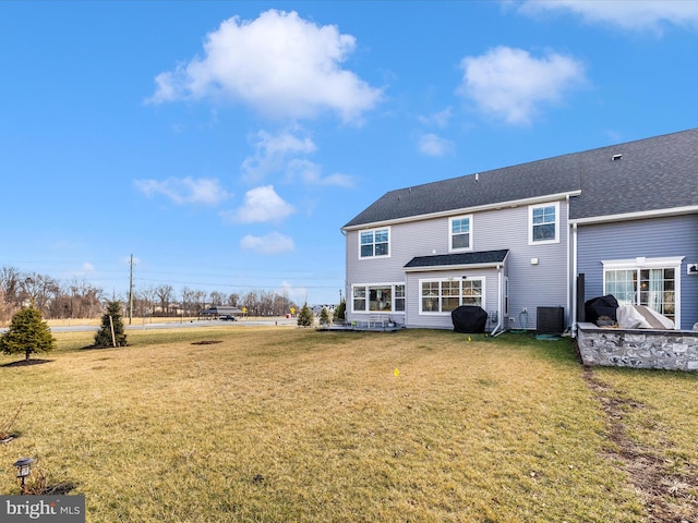 back of property with a yard and central air condition unit