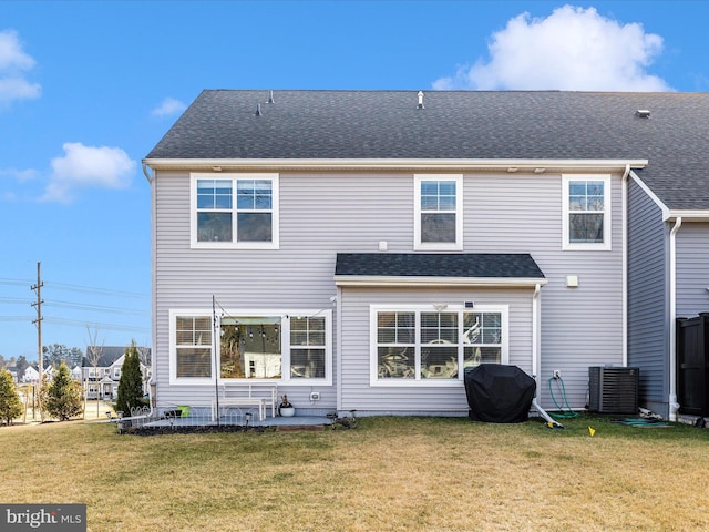 rear view of property with cooling unit and a yard