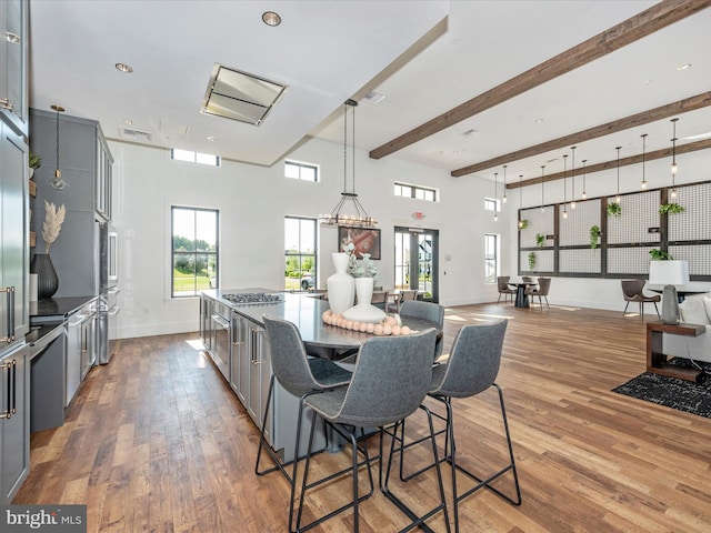 kitchen with hardwood / wood-style flooring, beam ceiling, and gray cabinetry