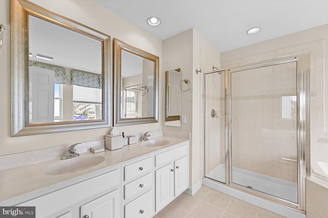 bathroom with tile patterned flooring, vanity, and a shower with door