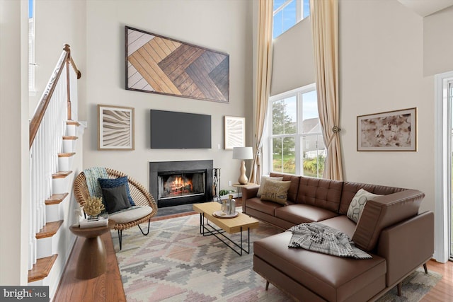 living room with a high ceiling and light wood-type flooring