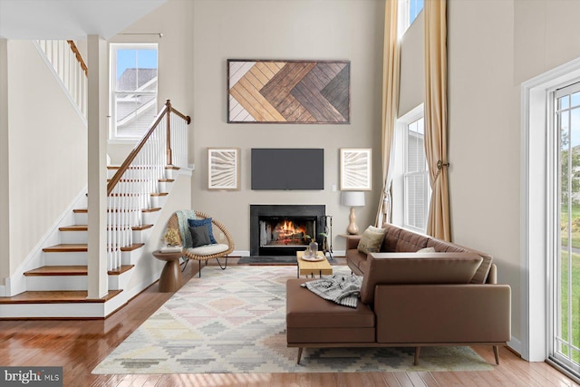 living room featuring hardwood / wood-style flooring and a towering ceiling