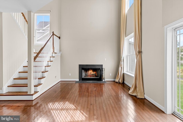 unfurnished living room with a high ceiling and hardwood / wood-style flooring