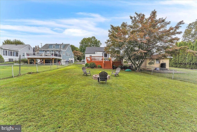 view of yard featuring a fenced backyard, a fire pit, and a wooden deck