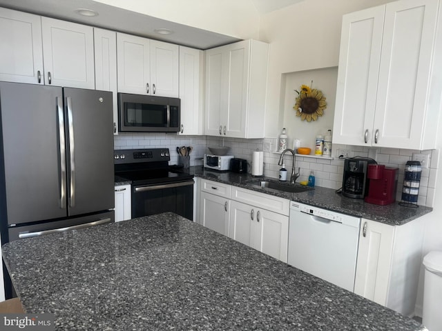 kitchen featuring stainless steel appliances, backsplash, a sink, and white cabinetry