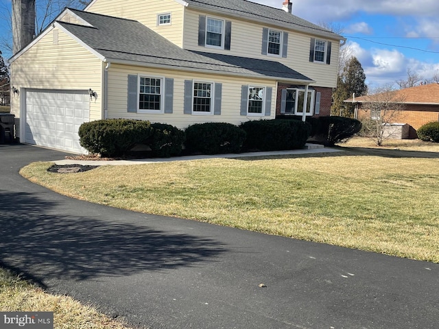 view of property with a garage and a front yard