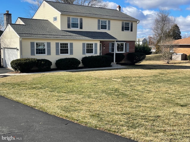 view of property with a garage and a front lawn