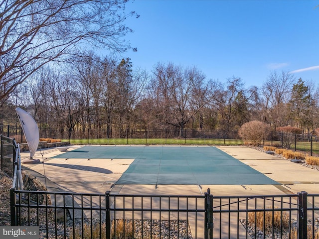 view of pool with a fenced in pool, fence, a patio, and a diving board