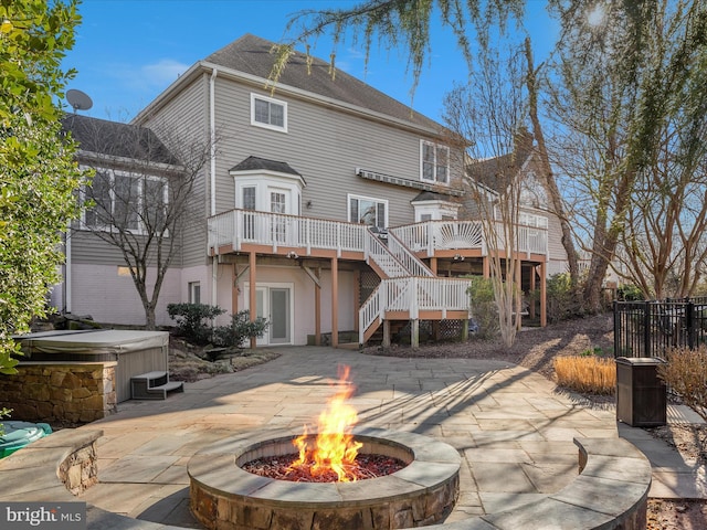 rear view of house with stairway, a hot tub, french doors, a deck, and a patio area