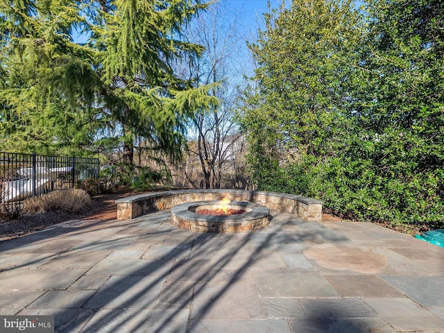 view of patio featuring a fire pit and fence