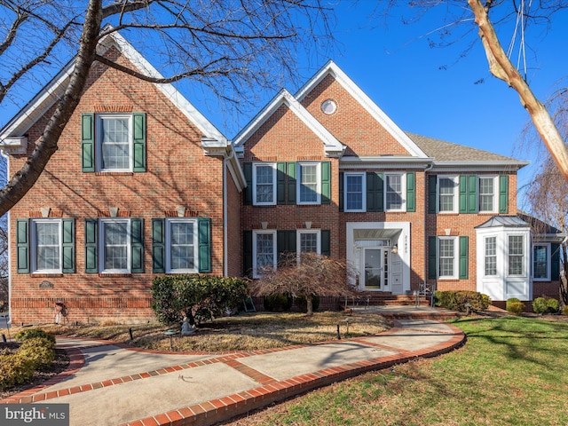 view of front facade with a front lawn and brick siding