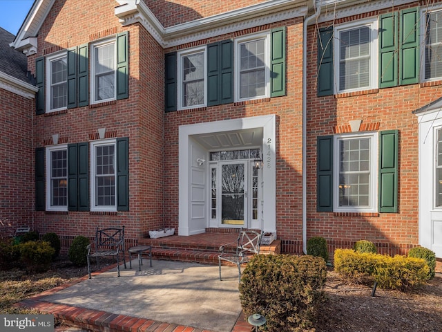 view of exterior entry with brick siding