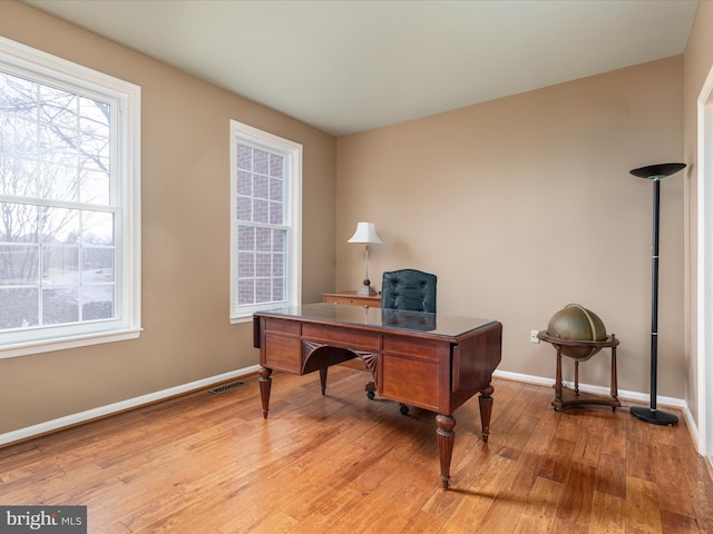 home office with visible vents, baseboards, and light wood-style flooring