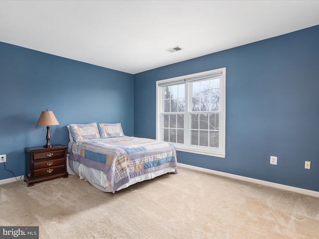 carpeted bedroom featuring visible vents and baseboards