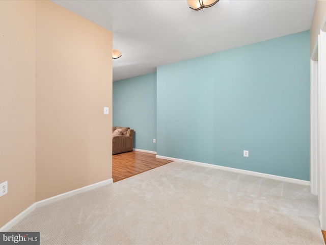 spare room with baseboards and carpet