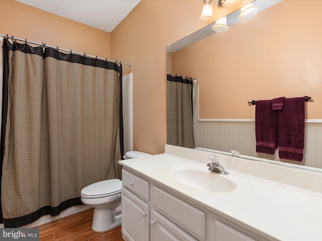 bathroom with curtained shower, toilet, wood finished floors, and vanity