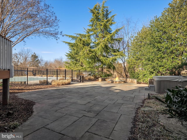 view of patio with a swimming pool, an outdoor fire pit, a hot tub, and fence