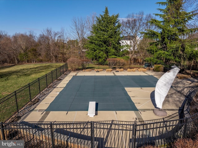 view of swimming pool featuring a lawn and fence