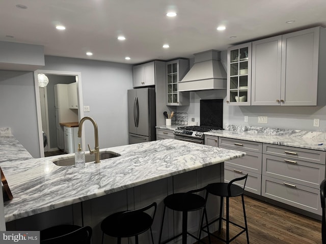 kitchen featuring stainless steel appliances, custom exhaust hood, gray cabinetry, and glass insert cabinets