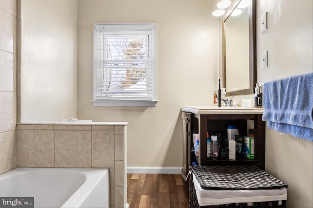 bathroom featuring vanity, hardwood / wood-style floors, and a tub