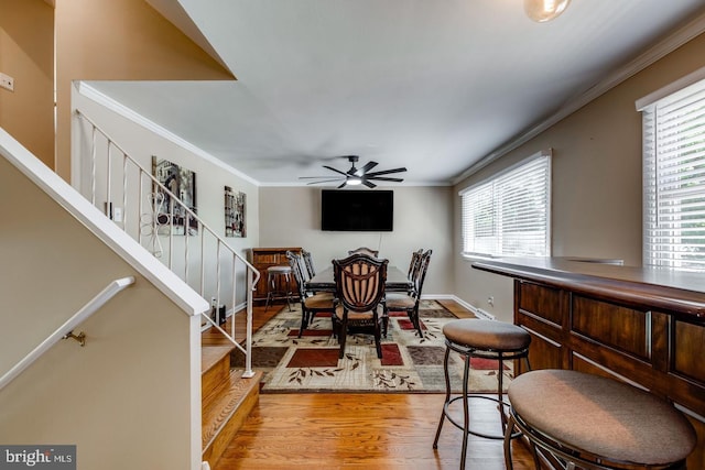 dining area featuring ornamental molding, ceiling fan, and light hardwood / wood-style flooring