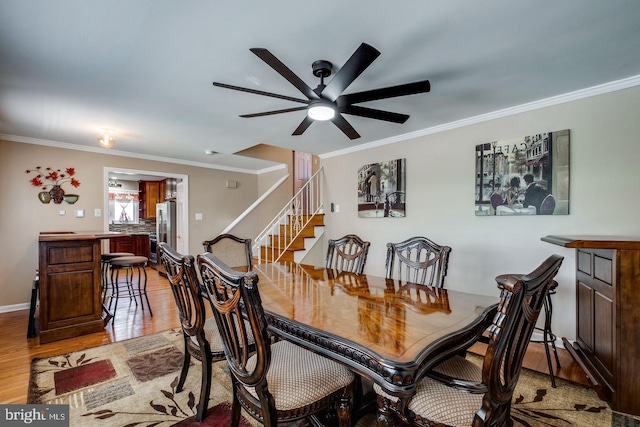 dining space with ornamental molding, ceiling fan, and light hardwood / wood-style flooring