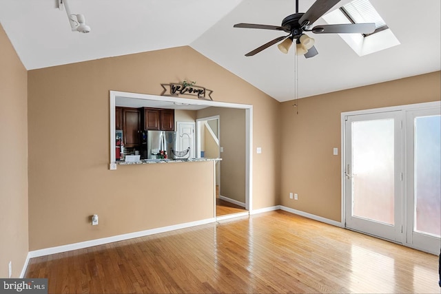 unfurnished room with vaulted ceiling, ceiling fan, and light wood-type flooring