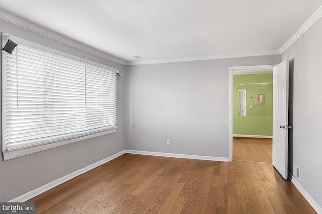 spare room featuring crown molding and hardwood / wood-style floors