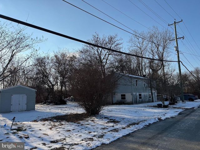 view of snowy exterior with a storage shed