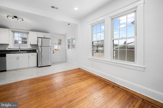 kitchen featuring a healthy amount of sunlight, sink, white cabinets, and appliances with stainless steel finishes