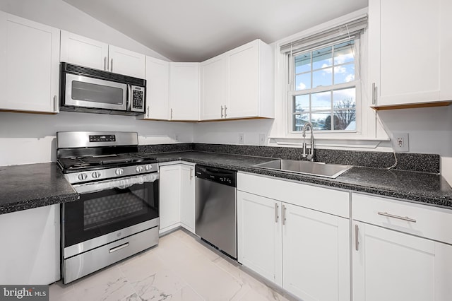 kitchen with white cabinetry, stainless steel appliances, vaulted ceiling, and sink