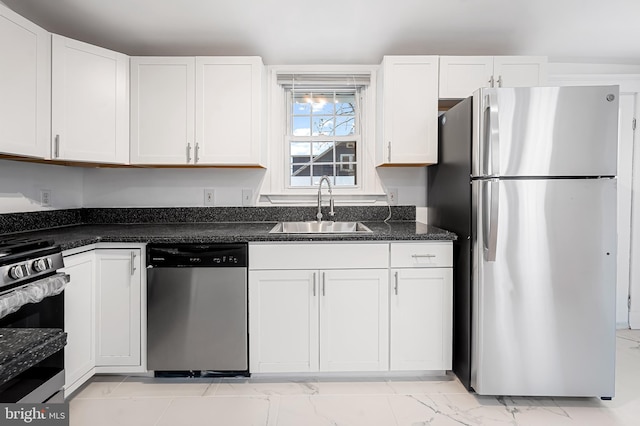 kitchen with sink, dark stone counters, white cabinets, and appliances with stainless steel finishes