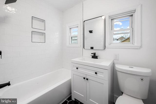 full bathroom with vanity, plenty of natural light, tiled shower / bath, and toilet