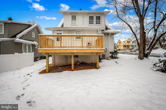 snow covered house with a deck