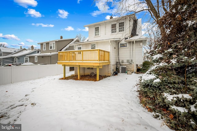 snow covered rear of property featuring a deck and central air condition unit