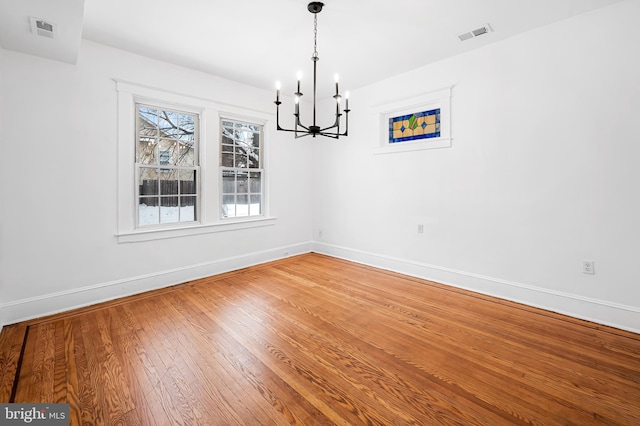 unfurnished dining area featuring hardwood / wood-style floors and a chandelier