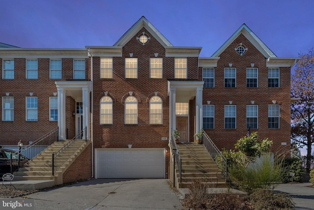 view of front facade with a garage, concrete driveway, and brick siding