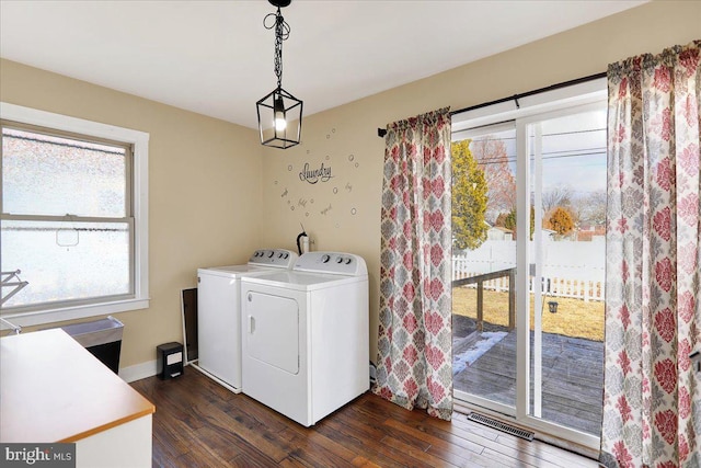 laundry area featuring dark hardwood / wood-style flooring, independent washer and dryer, and a wealth of natural light