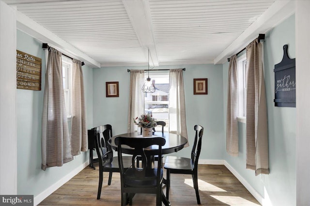 dining room featuring hardwood / wood-style floors and beamed ceiling